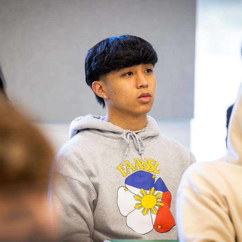 Students listen attentively during a classroom discussion or presentation on campus.